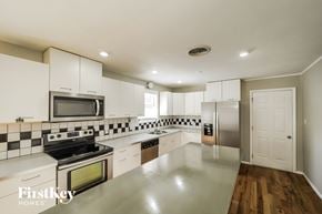 Smyrna house for rent - a large kitchen with white cabinets and stainless steel appliances