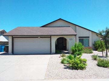Phoenix house for rent - a white house with a garage door and a gravel driveway