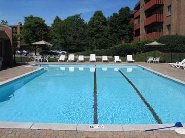 Highland Park apartment for rent - a large swimming pool with chairs and umbrellas