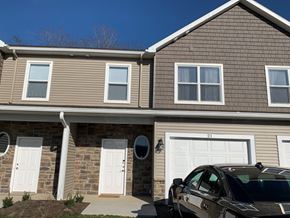 Penn Yan apartment for rent - a brown house with white doors and a black car parked in front