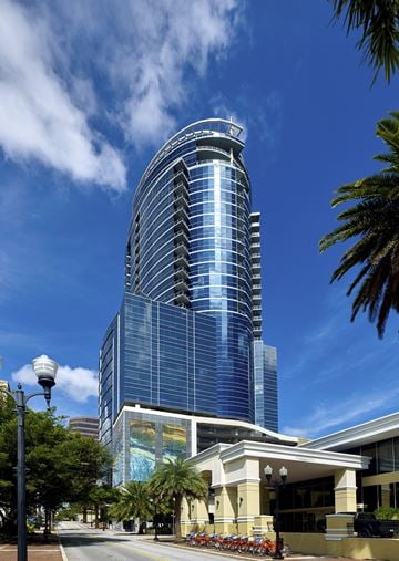 Orlando apartment for rent - a tall building with a blue sky background and palm trees