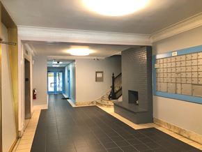 Boston apartment for rent - A hallway with a fireplace and a calendar on the wall.