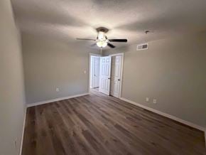 East Point apartment for rent - A room with a ceiling fan and wooden flooring.