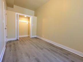 Chicago apartment for rent - an empty living room with wooden floors and a door to a hallway