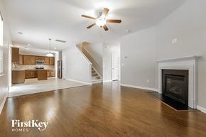Moncks Corner house for rent - an empty living room with a fireplace and a ceiling fan
