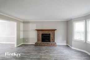 Lawrenceville house for rent - an empty living room with a brick fireplace