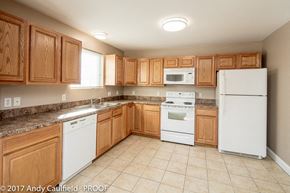 Andover apartment for rent - A kitchen with wooden cabinets and white appliances.