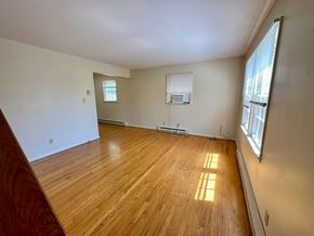 Charlottesville apartment for rent - A room with wooden flooring and a window on the right side.