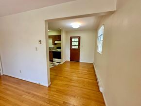 Charlottesville apartment for rent - A room with wooden floors and a doorway leading to another room.