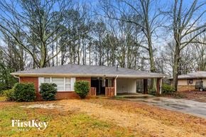 Powder Springs house for rent - A house with a porch and a tree in front of it.