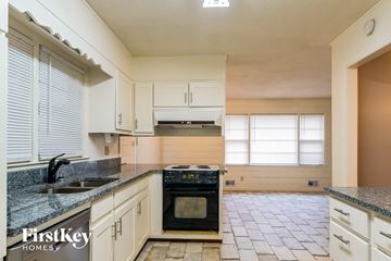 Powder Springs house for rent - A kitchen with a black oven and a tiled floor.