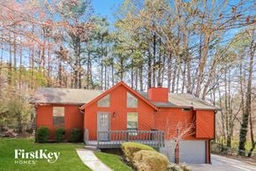 Woodstock house for rent - a small red house with a porch and trees