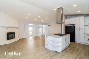 Woodstock house for rent - a white kitchen with a large island and a fireplace