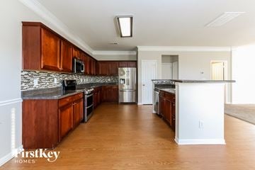 Gastonia house for rent - A kitchen with wooden cabinets and a white island.