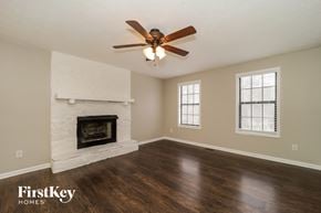 Douglasville house for rent - a living room with a ceiling fan and a fireplace