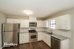Douglasville house for rent - a kitchen with white cabinets and stainless steel appliances