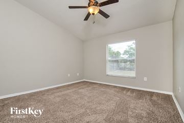 Lakeland house for rent - the living room of a house with carpet and a ceiling fan