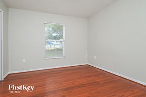 Lakeland house for rent - a bedroom with wood floors and white walls and a window