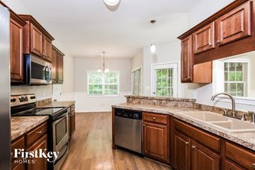 Hiram house for rent - A kitchen with wooden cabinets and a stainless steel dishwasher.