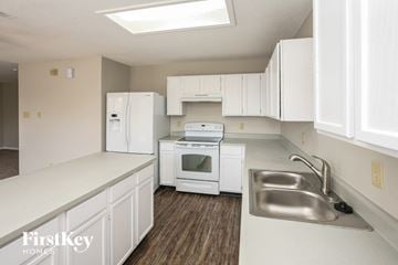 Plainfield house for rent - a white kitchen with white appliances and white cabinets