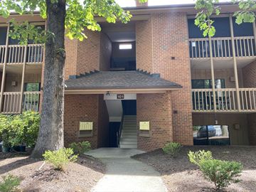 Charlottesville apartment for rent - the entrance to an apartment building with a tree in front of it