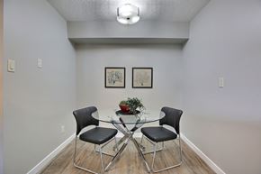 Regina apartment for rent - A dining room with a glass table and four chairs.
