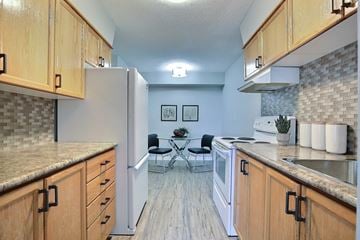 Regina apartment for rent - A kitchen with wooden cabinets and a white refrigerator.