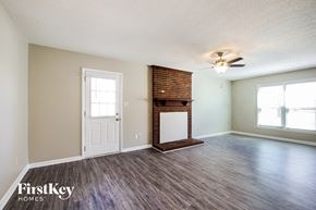 Charlotte house for rent - A room with a fireplace and a ceiling fan.