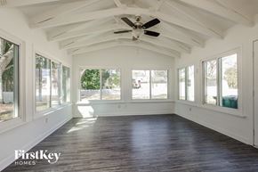 Charlotte house for rent - A spacious room with wooden floors and a ceiling fan.