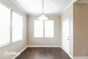 Baytown house for rent - an empty dining room with wood floors and a white light fixture
