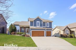 Kansas City house for rent - a blue house with a driveway and a garage door