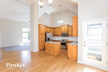 Kansas City house for rent - a kitchen with wooden cabinets and a door to the living room