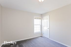 Kansas City house for rent - a bedroom with white walls and a door and a window