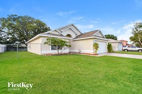 Poinciana house for rent - a white house with a yard and a fence