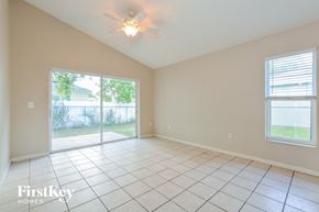 Poinciana house for rent - an empty living room with a ceiling fan and a sliding glass door