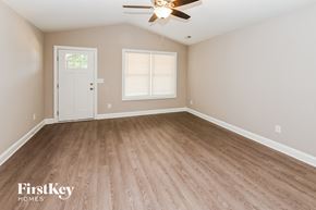 Kannapolis house for rent - A room with a ceiling fan and wooden flooring.
