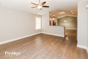 Kannapolis house for rent - A spacious room with wooden flooring and a ceiling fan.