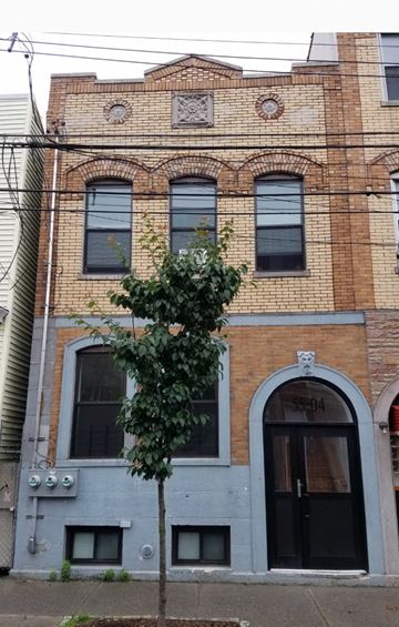 Corona apartment for rent - A tree in front of a building with a blue door.