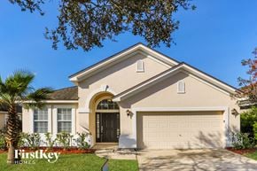Jacksonville house for rent - A house with a garage door and a palm tree in front.