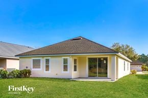 Jacksonville house for rent - A house with a white exterior and a brown roof is shown with the words "FirstKey Homes" on the bottom left.