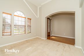 Mansfield house for rent - an empty living room with a large arched door and windows
