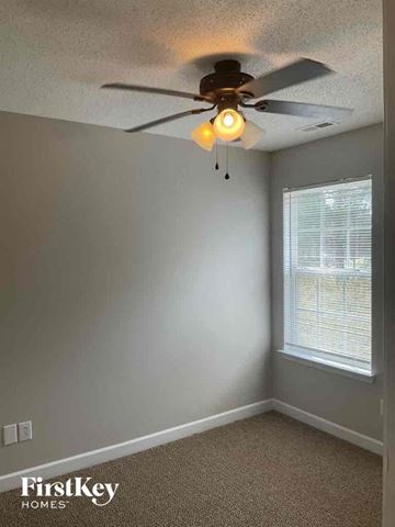 Charlotte house for rent - a bedroom with a ceiling fan and a window