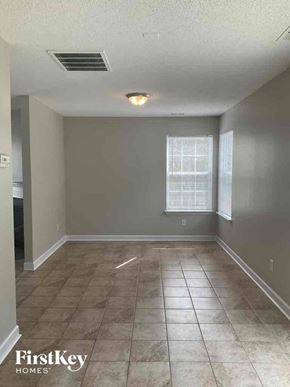Charlotte house for rent - an empty living room with tile flooring and a window