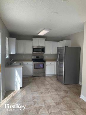 Charlotte house for rent - an empty kitchen with stainless steel appliances and white cabinets