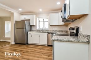 Greensboro house for rent - a kitchen with white cabinets and stainless steel appliances