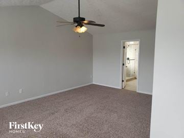 Amelia house for rent - a living room with a ceiling fan and a carpet