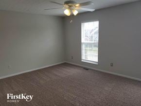 Amelia house for rent - a bedroom with a ceiling fan and a window