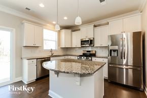Sherrills Ford house for rent - a kitchen with white cabinets and granite counter tops and stainless steel appliances