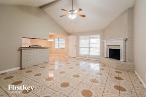 Spring house for rent - A spacious living room with a fireplace and a fan.