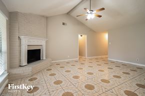 Spring house for rent - A room with a fireplace and a ceiling fan.